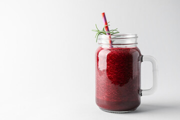 Fresh beetroot smoothie in mason jar on light background, closeup. Space for text