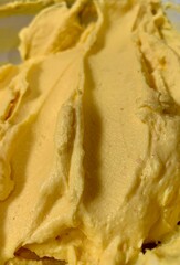 This creamy yellow butter blend sits in a bowl, showcasing a smooth and rich texture perfect for incorporating into various recipes. Its vibrant color indicates freshness and quality