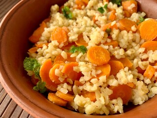 A vibrant bulgur salad featuring finely chopped carrots and fresh herbs is beautifully presented in a rustic bowl. This healthy dish is perfect for a light meal