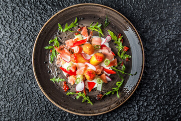 delicious and colorful smoked salmon salad with a mix of leaves, cheeses, cold cuts accompanied by sweet potato chips