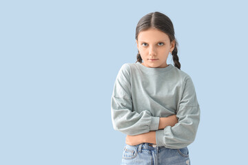 Cute girl suffering from bellyache on blue background