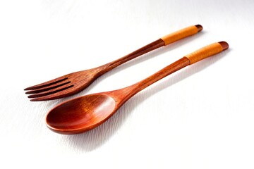 Wooden spoon and fork on white background
