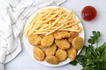 Tasty chicken nuggets and french fries with sauce on white tiled table, flat lay