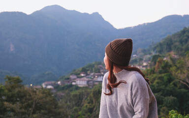 Rear view of a woman looking at a rural village and mountain views