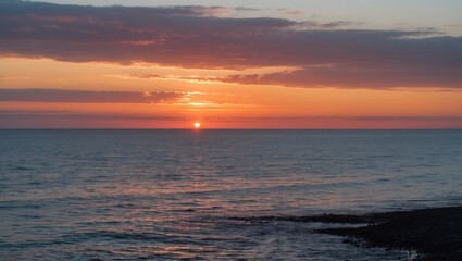 Obraz premium Tranquil Sunset Over the North Sea With Reflections on Water and Space for Text Inclusion