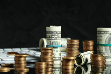 Stacks of coins and dollar banknotes on black background, closeup. Wealth concept