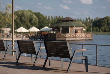 LANDSCAPE BY LAKE - Wooden benches on the recreational and viewing platform of the Szczecinek city park
