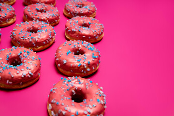 Colorful donuts on a pink background