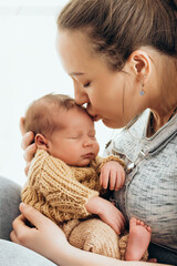 a mother holds a newborn sleeping baby in her arms, gently hugging and kissing him, a healthy baby's sleep in his mother's arms, maternal love and care