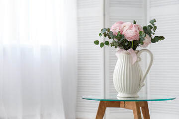 Vase with bouquet of beautiful ranunculus flowers on coffee table in living room, closeup