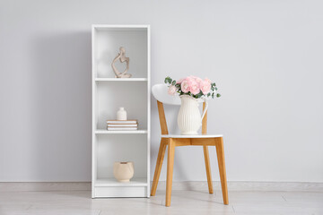 Vase with bouquet of beautiful ranunculus flowers on chair in living room