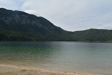 Majestic alpine landscape featuring crystal-clear lakes surrounded by high mountains and dense pine...