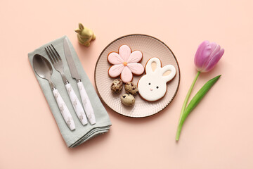 Beautiful table setting with sweet cookies, quail eggs and tulip flower on beige background. Easter celebration
