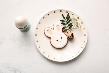 Beautiful table setting with sweet cookies, eggs and gypsophila flowers on white background. Easter...