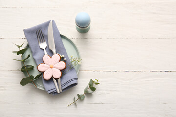 Beautiful table setting with sweet cookie, Easter egg, gypsophila flowers and eucalyptus branches...