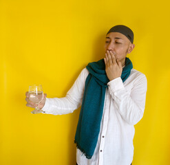 Asian Muslim Man Keeping His Mouth Shut While Holding Glass Of Water During Fasting On Ramadan
