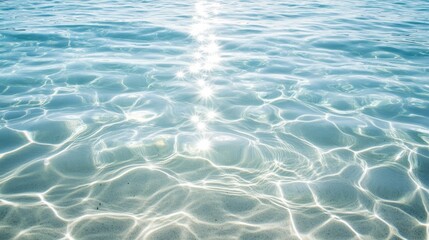 Fototapeta premium Smooth rippling patterns in transparent seawater, sunlight casting dreamy highlights over the delicate waves