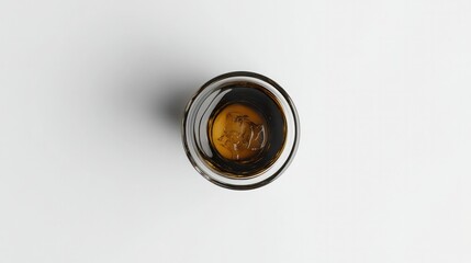 Top-down view of a transparent cup filled with iced Americano, deep brown coffee tones contrasting with the ice. White background