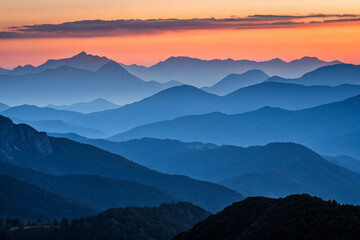silhouette of mountains at dusk, with layers of peaks fading into the distance