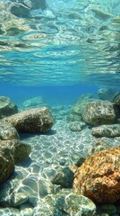 Underwater rocks forming a unique landscape beneath clear water with sunlight creating beautiful patterns and shadows