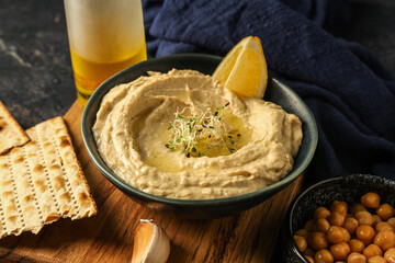 Bowl of delicious hummus with lemon, micro green, crispbread and chickpeas, closeup