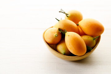 Plum Mango or Marian Plum fruit in wooden tray.