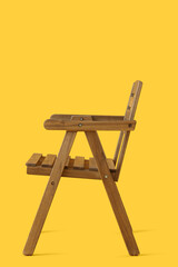 Modern wooden chair on yellow background