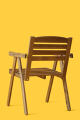 Stylish wooden chair on yellow background