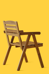 Stylish wooden chair on yellow background