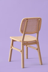 Modern wooden chair on lilac background