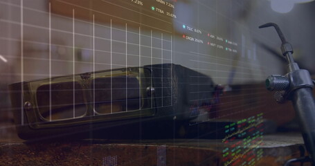 Image of financial data processing over goggles and tools in workshop