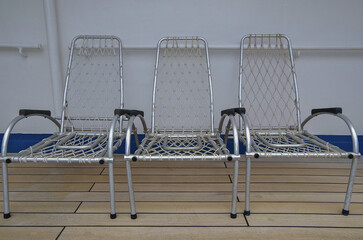 Outdoor promenade boat deck patio terrace with aluminium chairs under life boats onboard classic...