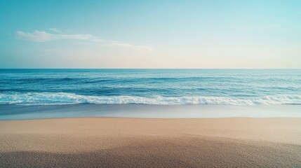 Coastal calm: Sandy beach meets gentle ocean waves under a serene sky 
