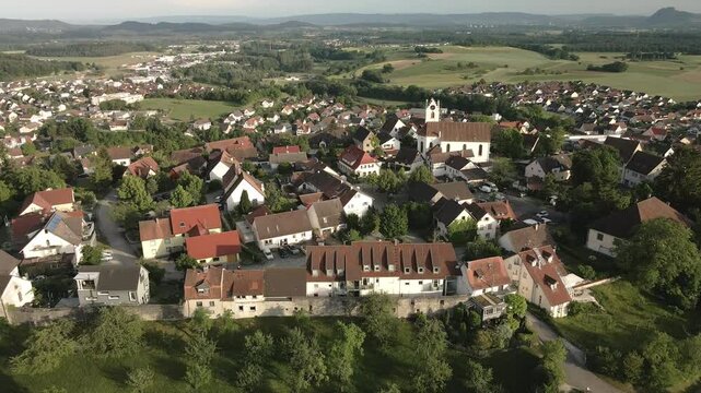 Drone footage descending over the historic old town of Aach, Baden-W&uuml;rttemberg, offering a detailed view of the village, its buildings, and the surrounding landscape.
