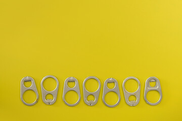 ANILLAS DE ALUMINIO PARA ABRIR BOTES SOBRE FONDO AMARILLO