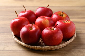 Red apple fruit (Gala apple) in basket on wooden background