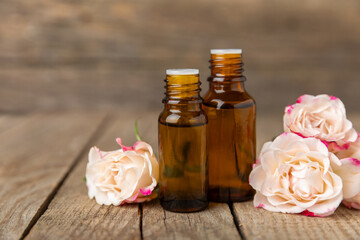 Rose essential oil on a textured background.Roses and a bottle of rose perfumed water.Aromatherapy...
