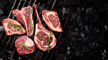 A large set of meat steaks cooked on an open fire. Barbecue. Tomahawk steak, Ribeye, Ossobuco and...
