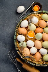 Raw organic chicken eggs on hay in a wooden box. Close up.