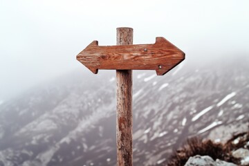 Rustic Wooden Signpost in Misty Mountain Landscape with Arrow Directions
