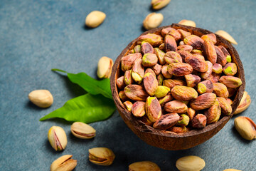 Shelled pistachio kernels in a wooden bowl. Close-up, side view.