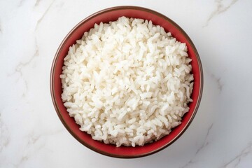 Bowl of cooked white rice on a marble background. Top view.