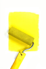 Painting a rough wall with roller. Paint roller leaving stroke of yellow color over a white background. usable for text and messages.