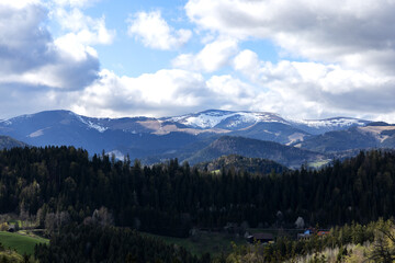 Hilly landscape in the Austrian Alps. Shadows in the valleys. Snow on the tops of high hills