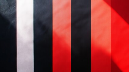Fototapeta premium Red fabric background with black and white stripes fading from light to dark.