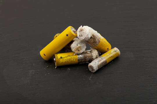Used batteries with expired shelf life. Old oxidized and leaking batteries, leakage of alkaline electrolyte. Dangerous caustic white powder. Problems of electronic waste recycling