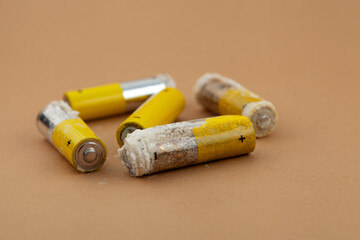 Defective expired batteries, selective focus. Oxidized and leaking alkaline batteries with formation of caustic white powder of potassium hydroxide. Problems of recycling electronic waste