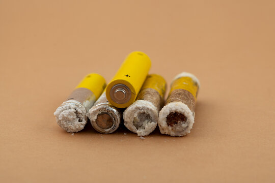 Old used alkaline batteries AA, close-up, selective focus. Oxidized and leaked batteries, leakage of alkaline electrolyte. Concept of Separate collection of garbage and electronic waste