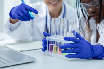 Diverse scientist working with test tube in laboratory conducting experiment for cure research