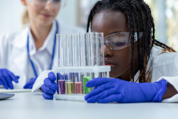 Females professional in clinic working with test tube conducting experiment on virus samples
